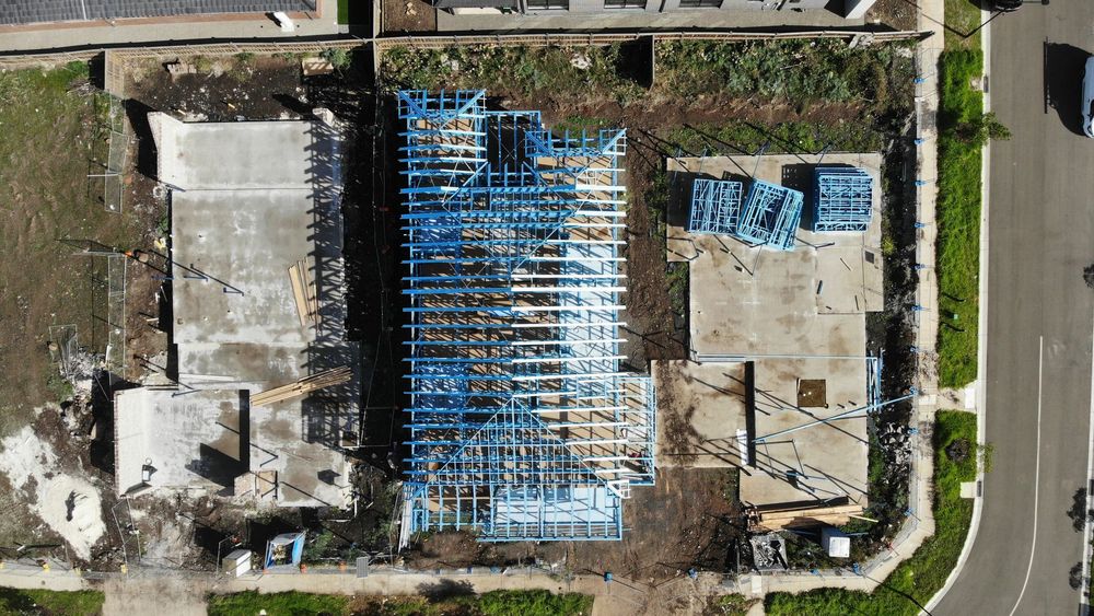 A house frame going up on a bounded plot